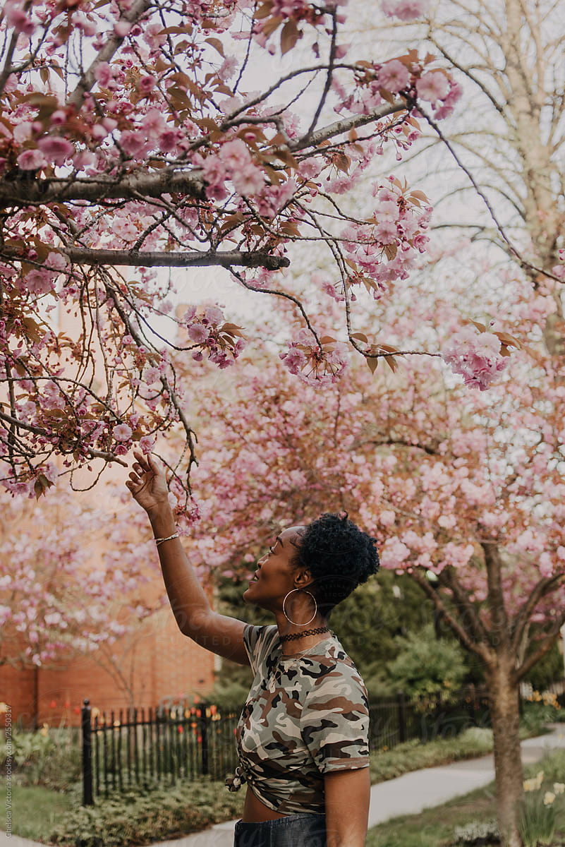 A young african american woman waking down a street in the spring