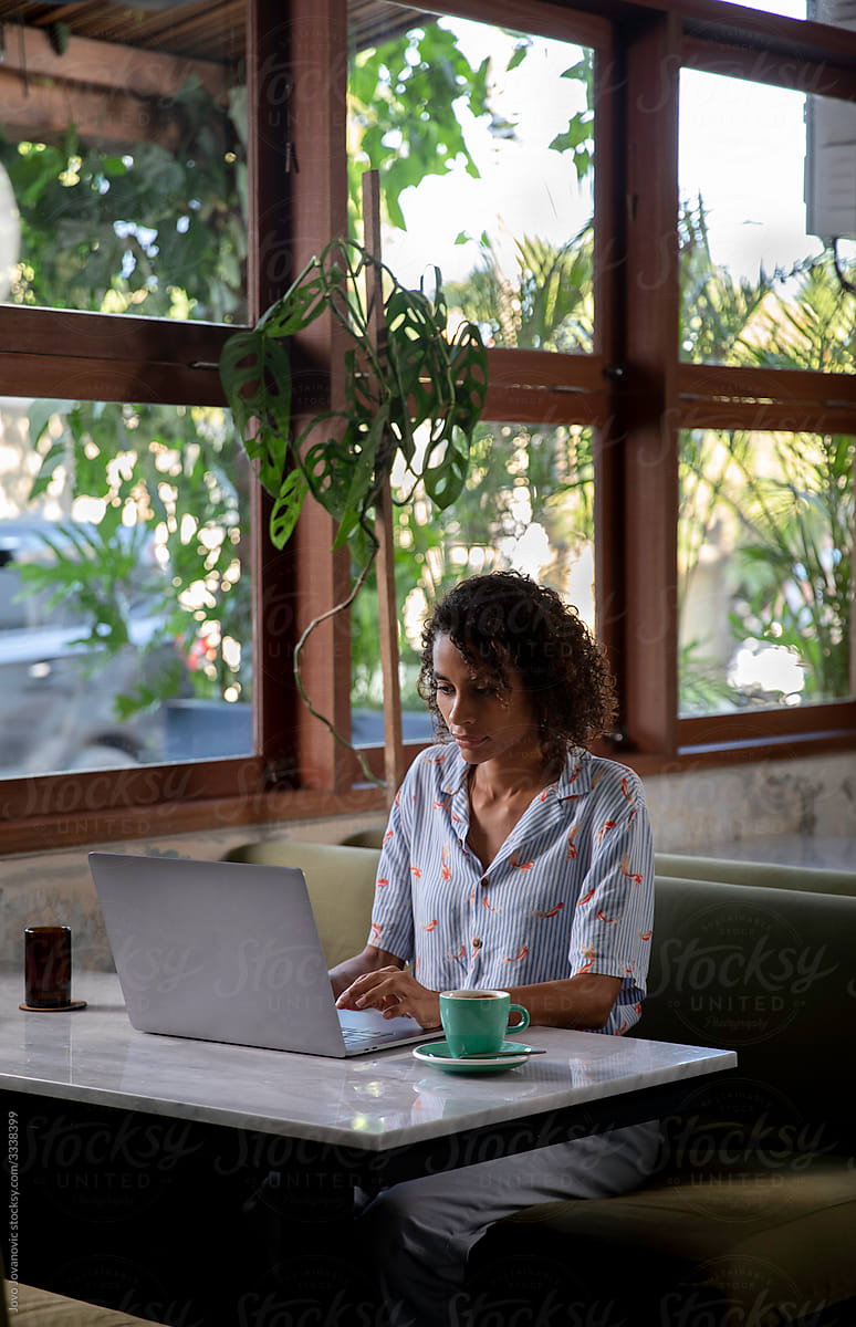 Confident woman working in a cafe on her laptop