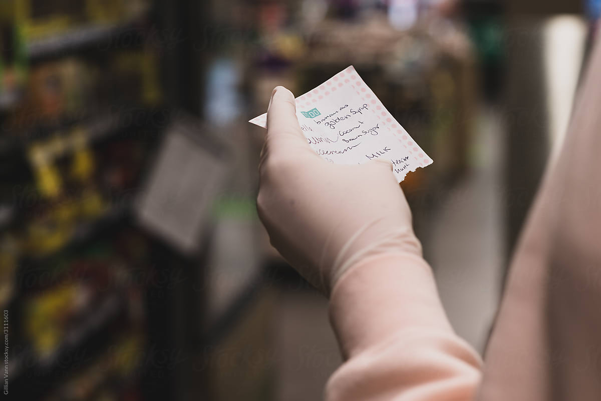 woman with handwritten shopping list at the supermarket