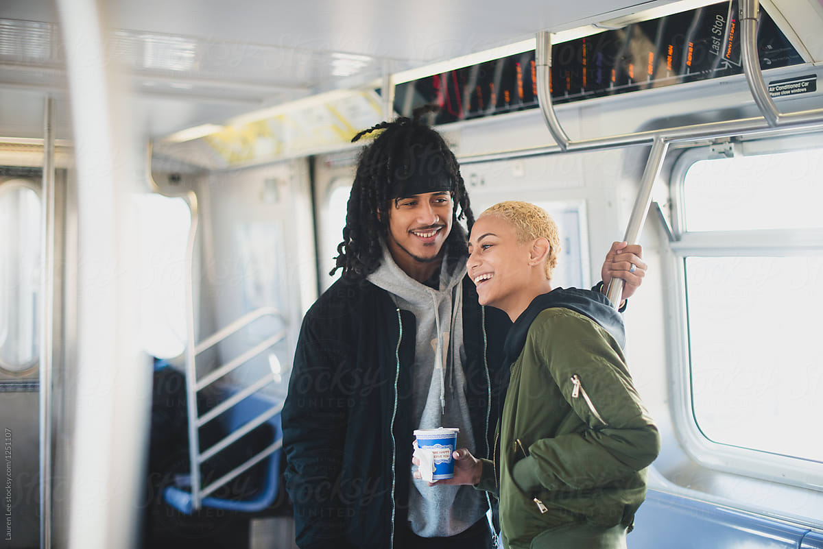 Couple laughing and riding subway together