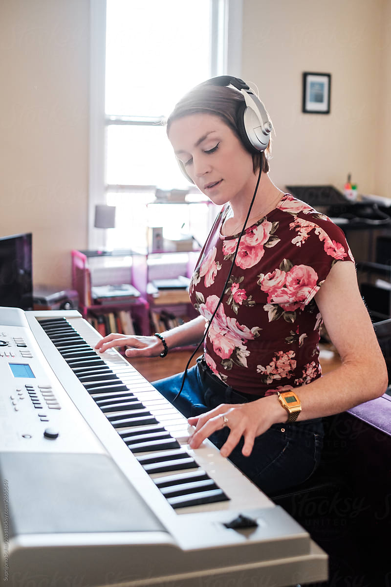 Woman playing piano keyboard at home