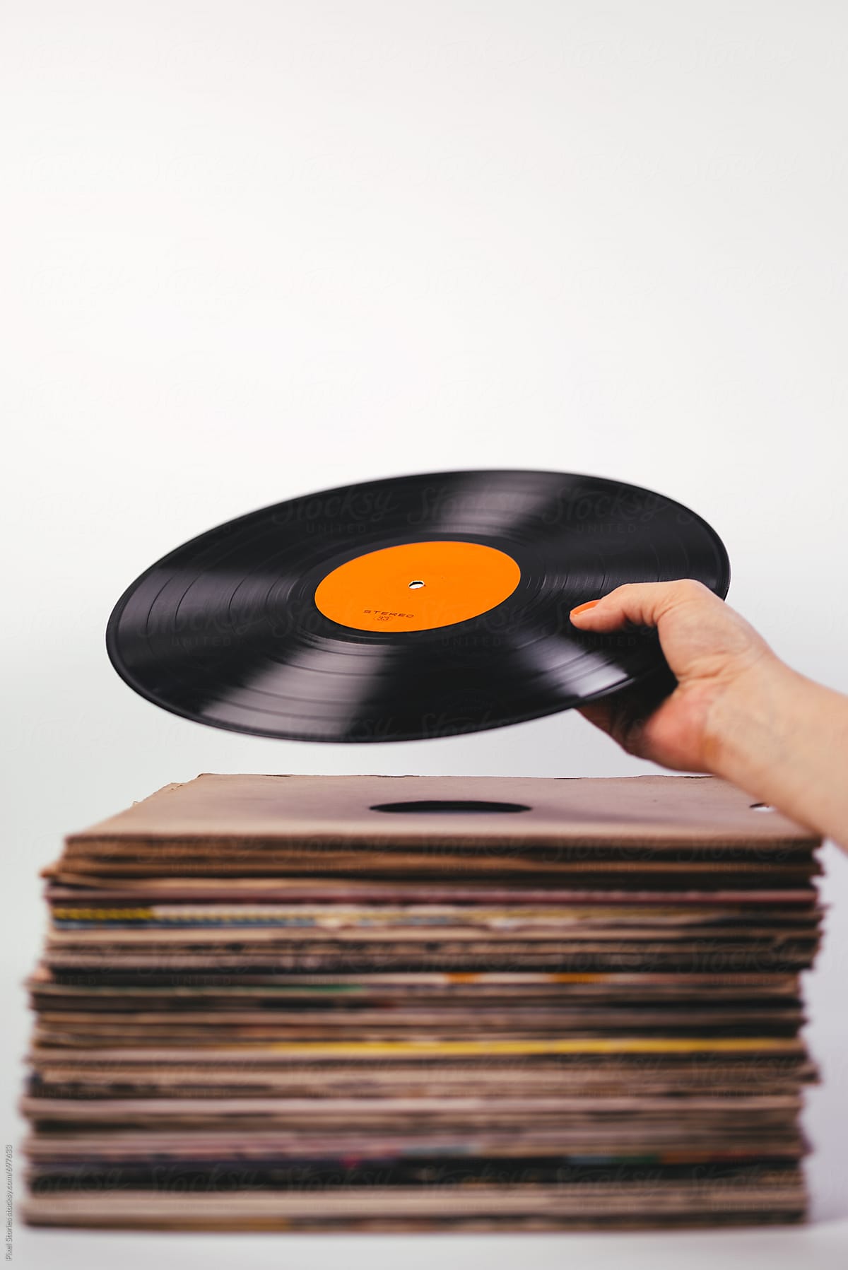 Hand picking vinyl record from stack