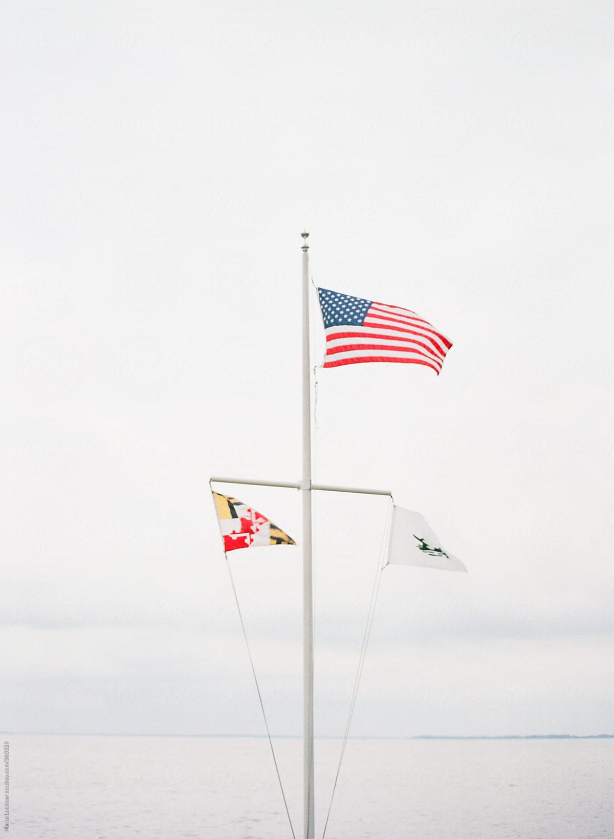 3 flags on a marine flag pole