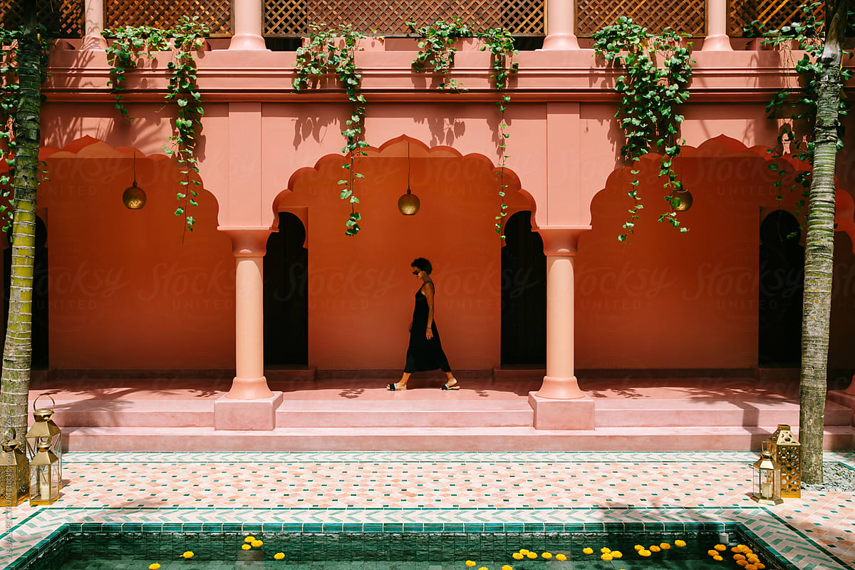 Woman Walking in Pink Courtyard