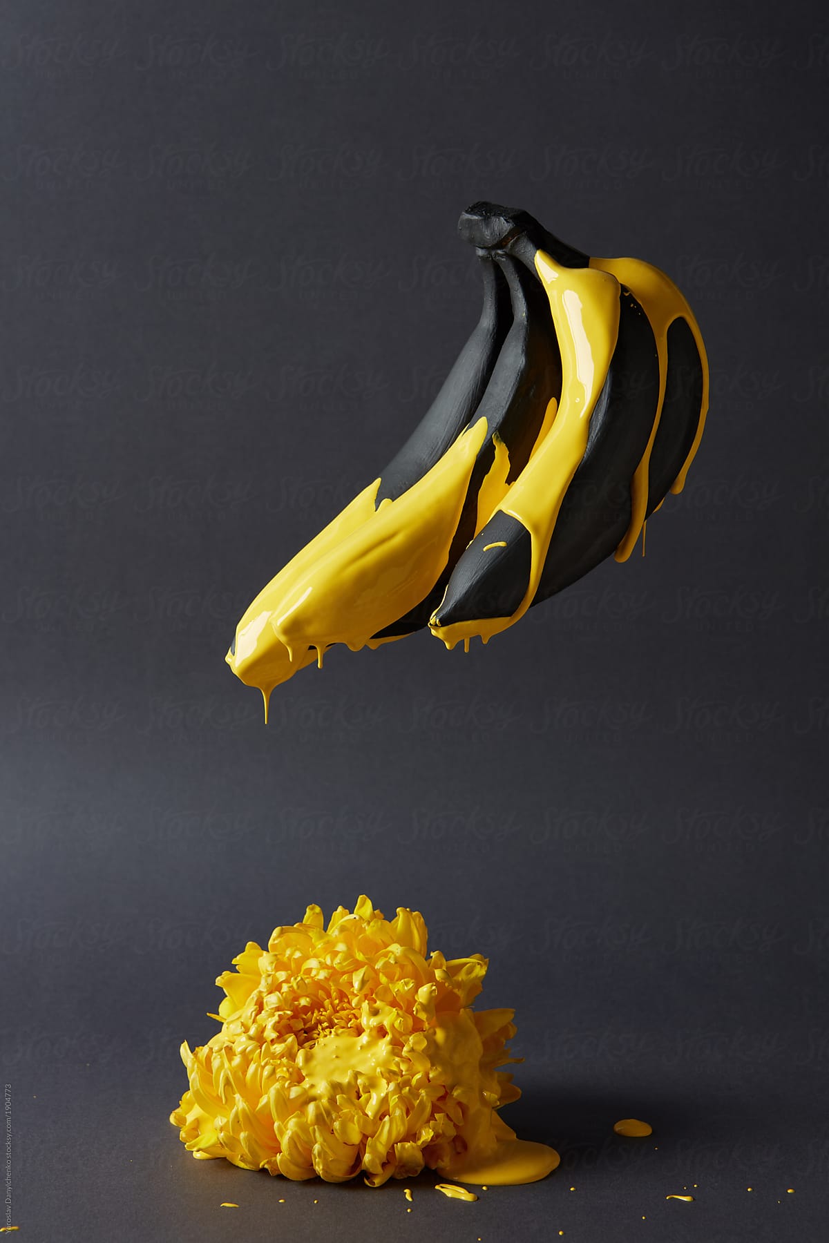 Bananas painted in yellow paint and chrysanthemum on a black background