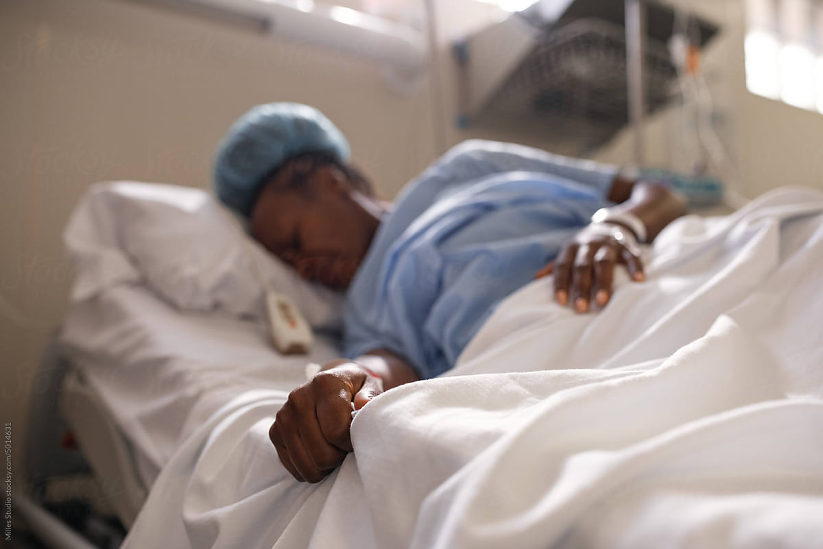 Black female grasping bedsheet during contractions
