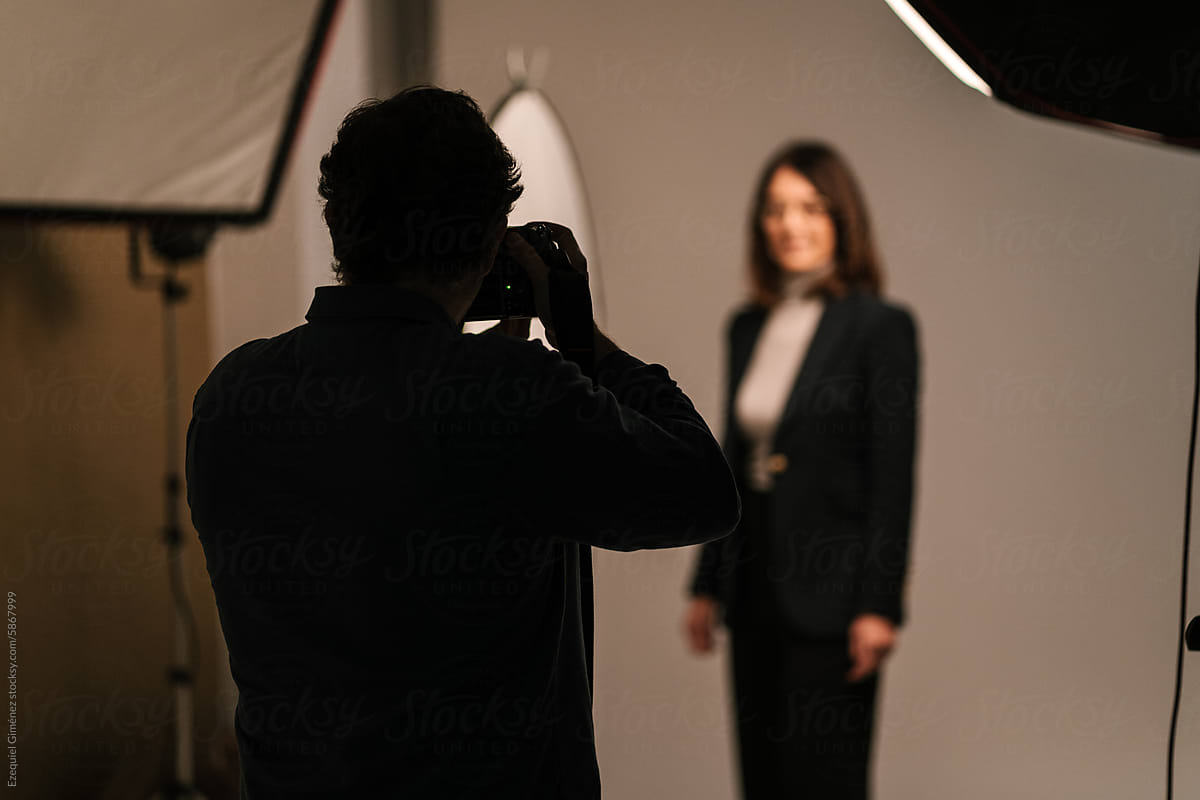 Silhouette of photographer shooting model in studio