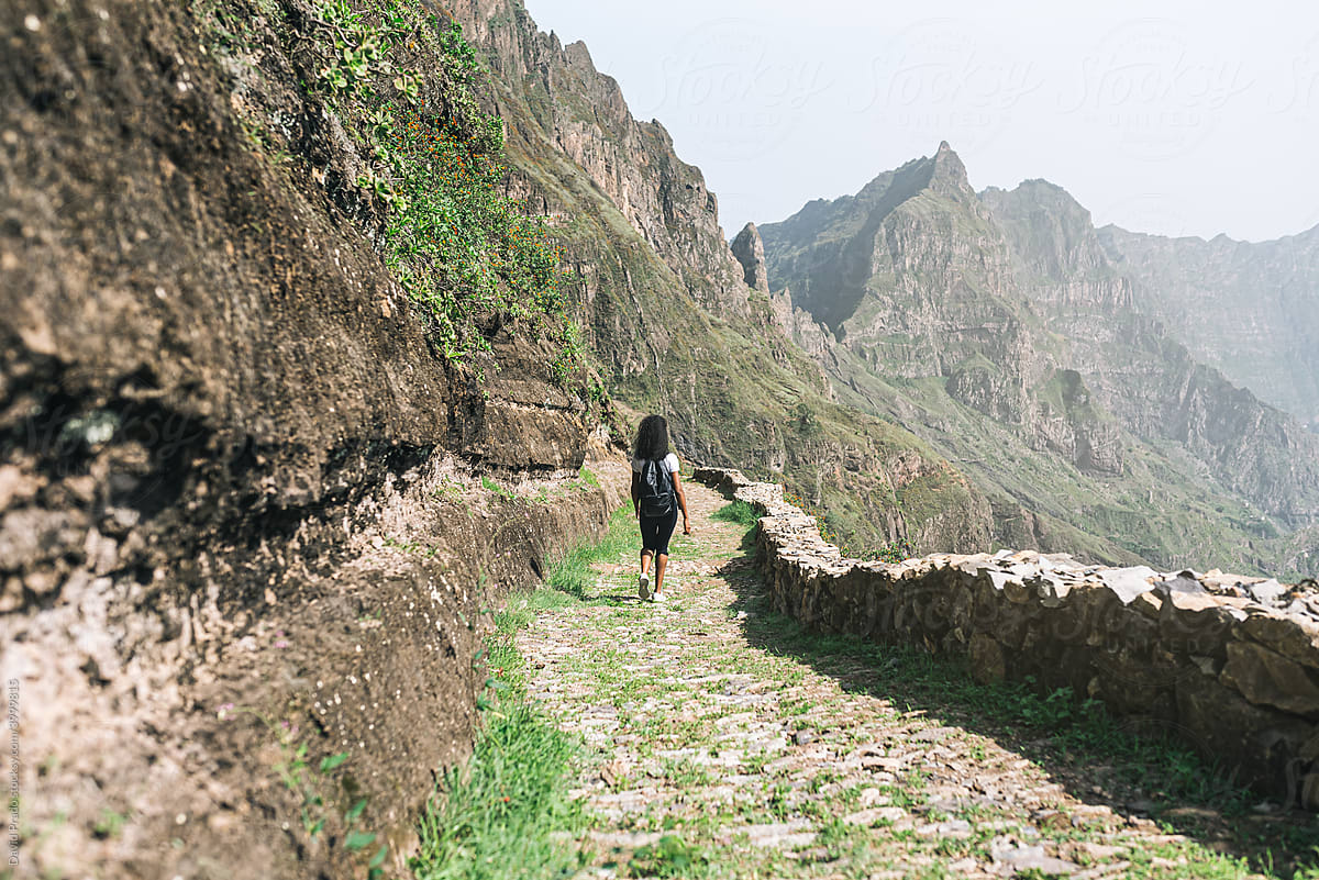 back view of black backpack woman hiking in mountains in Cape verde
