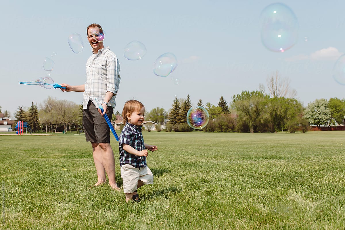 Father and son playing outdoors with bubble