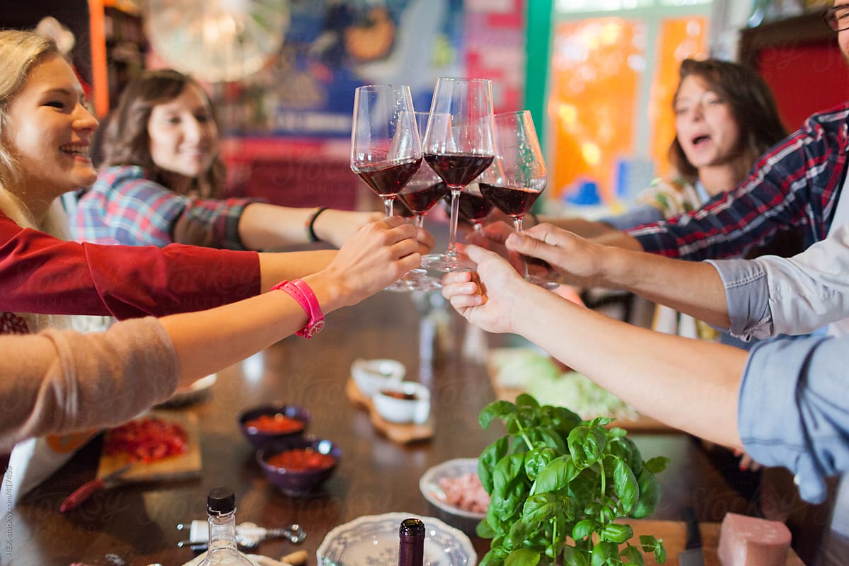 Large Group of Friends Cheering With Glass of Red Wine
