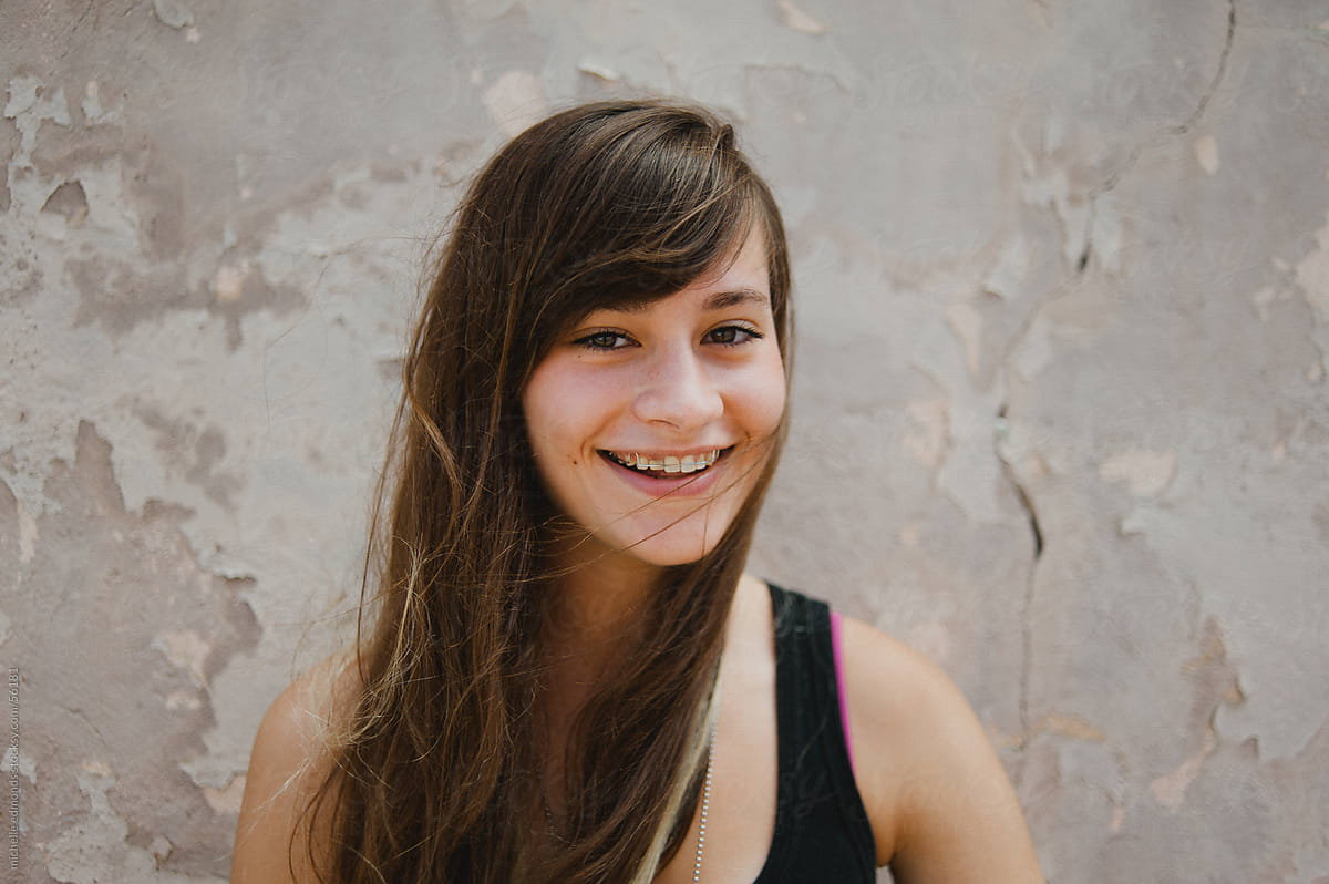 Teenaged Girl Smiling Against Urban Wall By Stocksy Contributor Michelle Edmonds Stocksy 7311