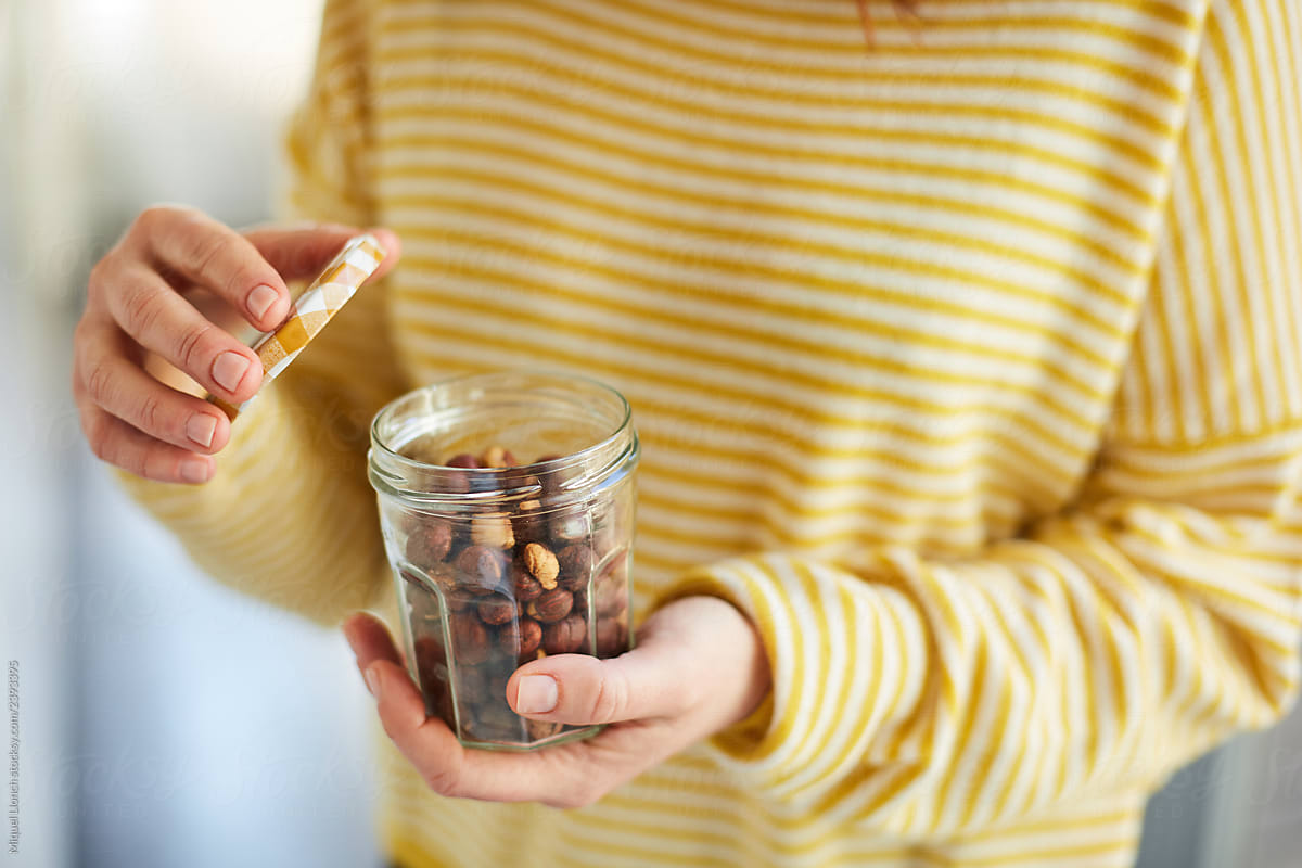 Woman hands holding a jar of hazelnuts