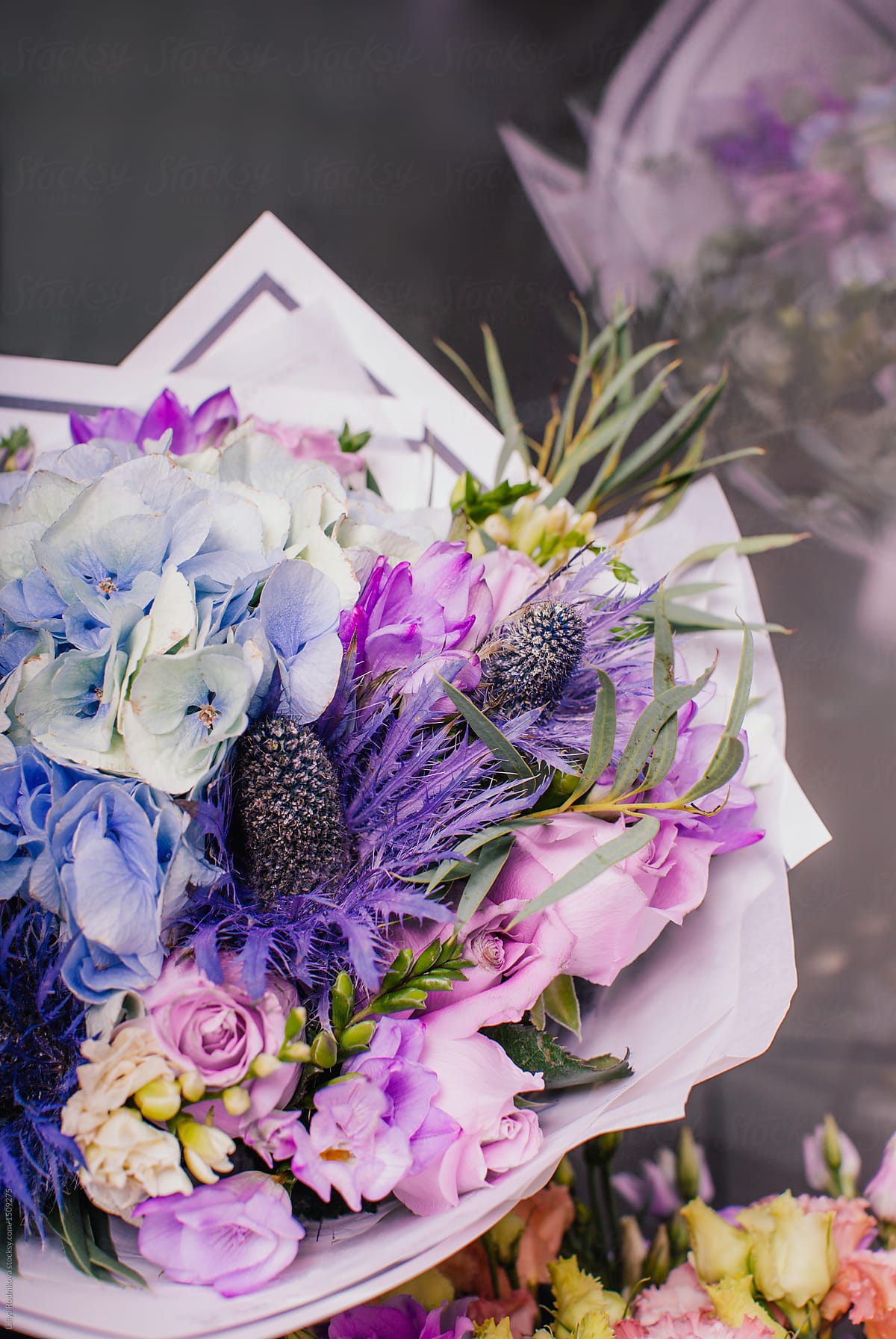 Arranged bouquet of violet flowers in package