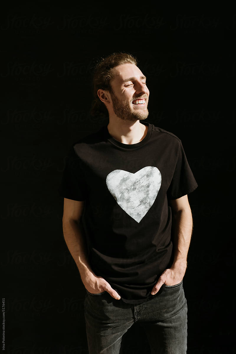 Modern male in black T-shirt with heart symbol.