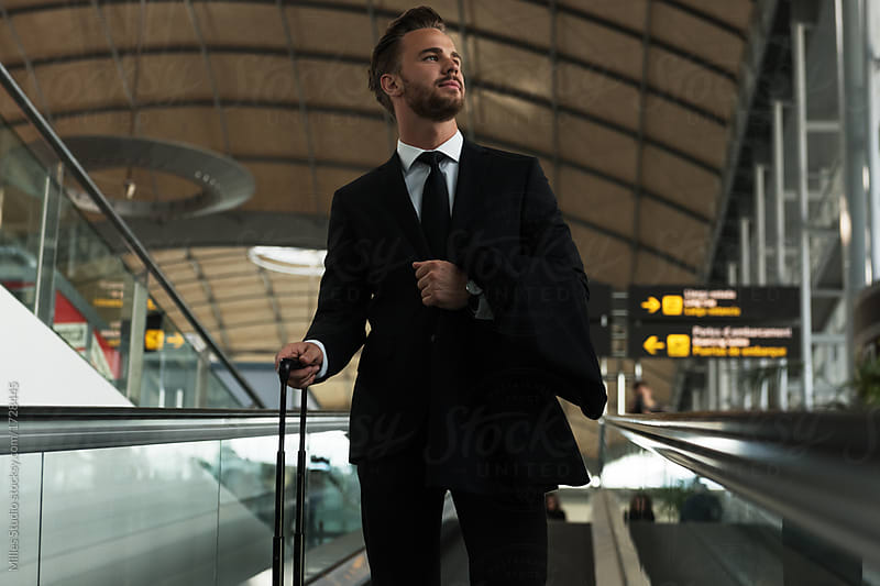 Trendy man in classy suit with luggage