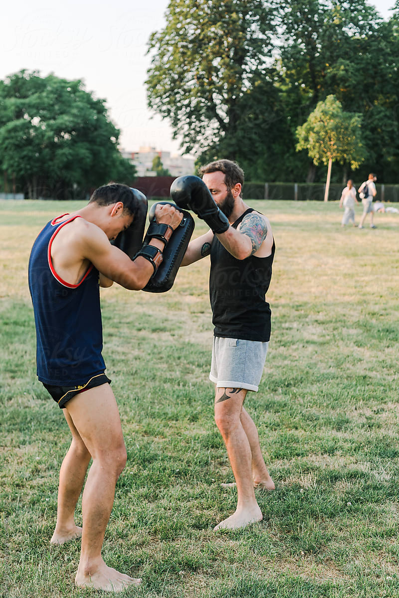 Two athletes engaged in outdoor Muay Thai training