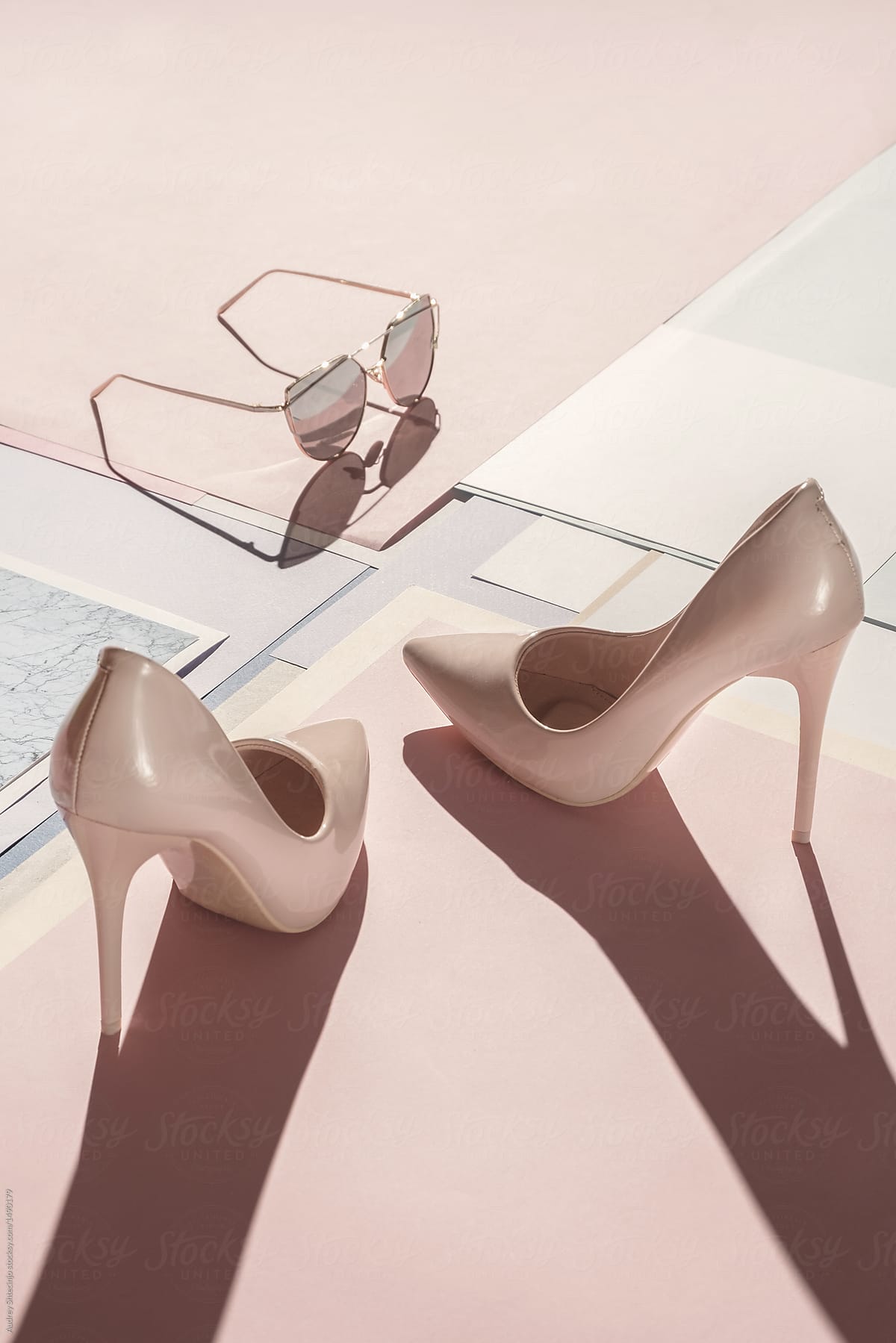 Composition of stylish high heel shoes with feminine accessories .