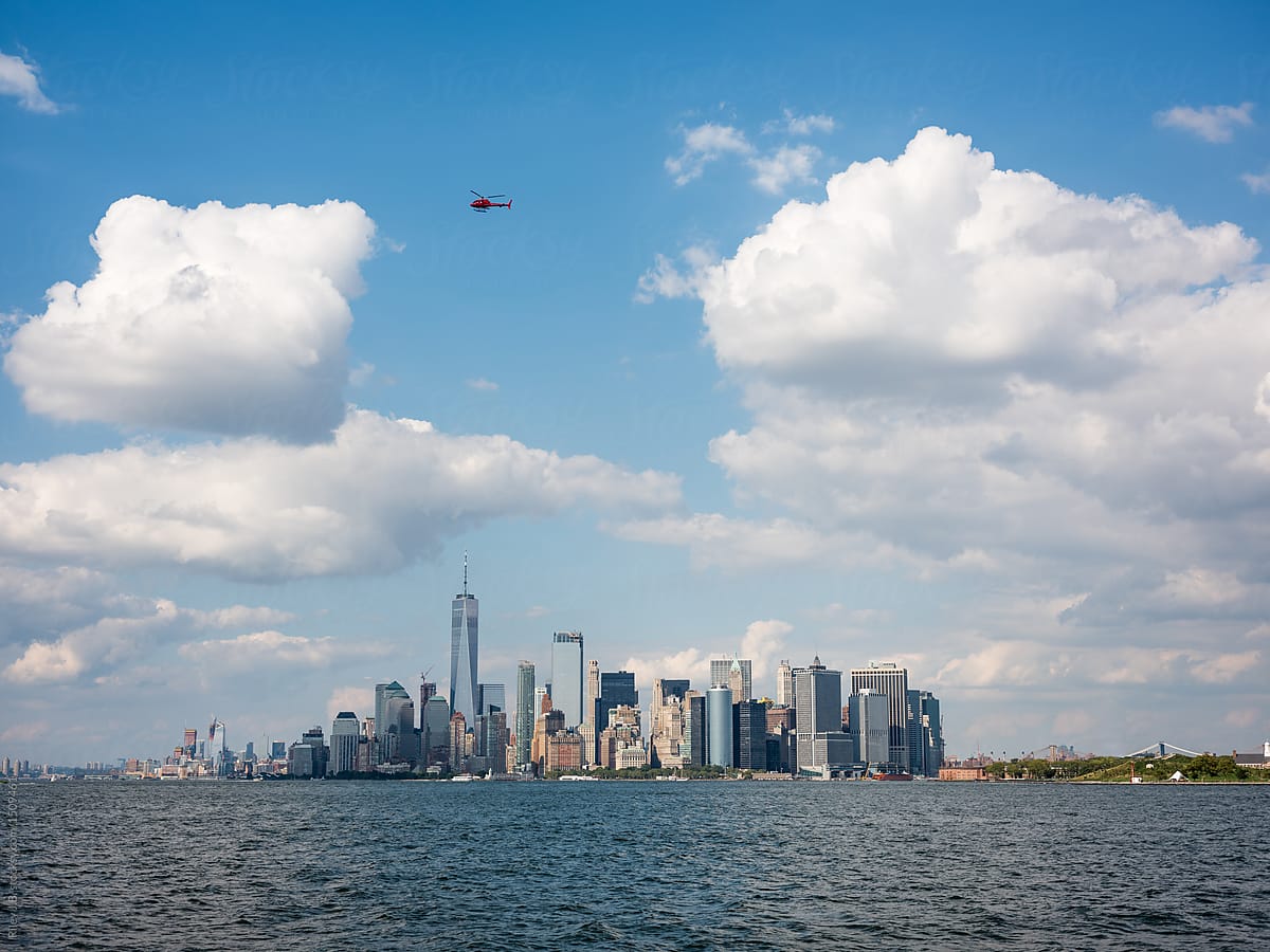 A red helicopter flies over lower Manhattan.