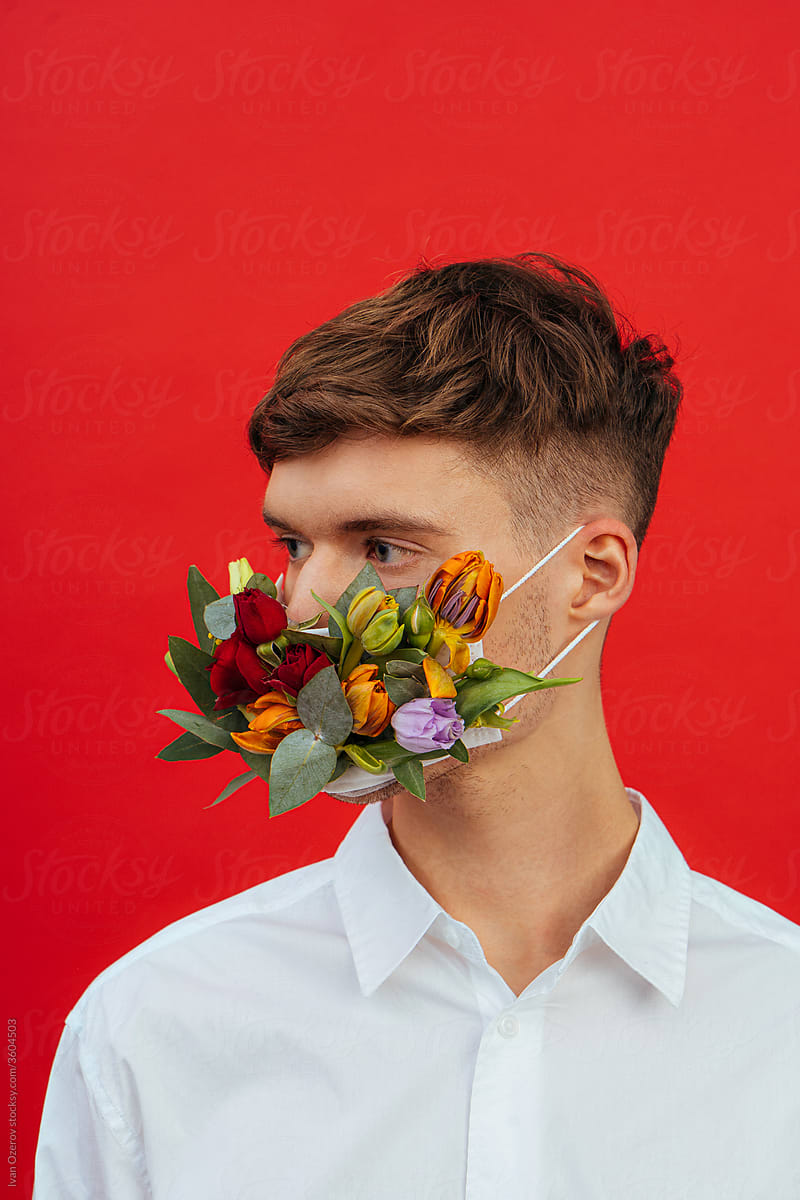 a man in a flower mask looking away