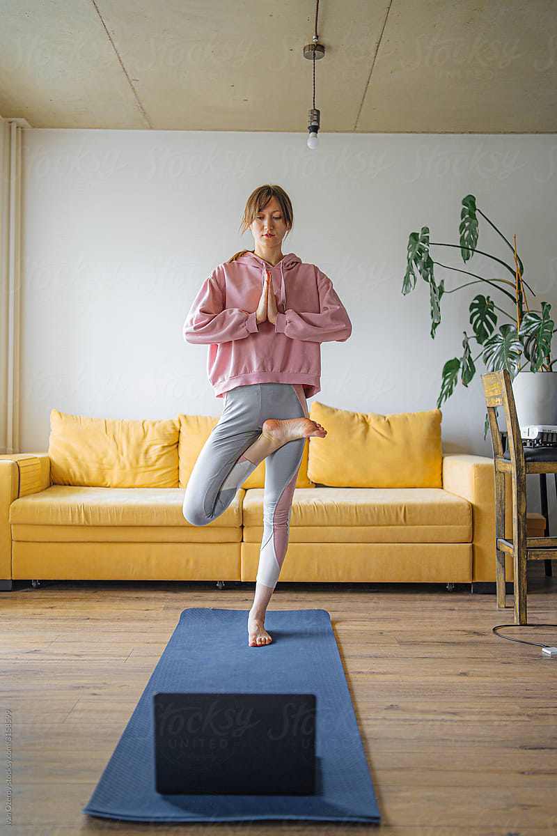 beautiful girl in sportswear conducts a yoga lesson from home via video calling
