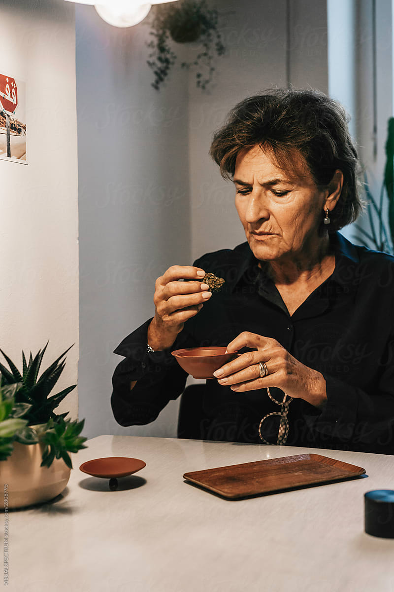 Old Woman Examining CBD Cannabis at Home