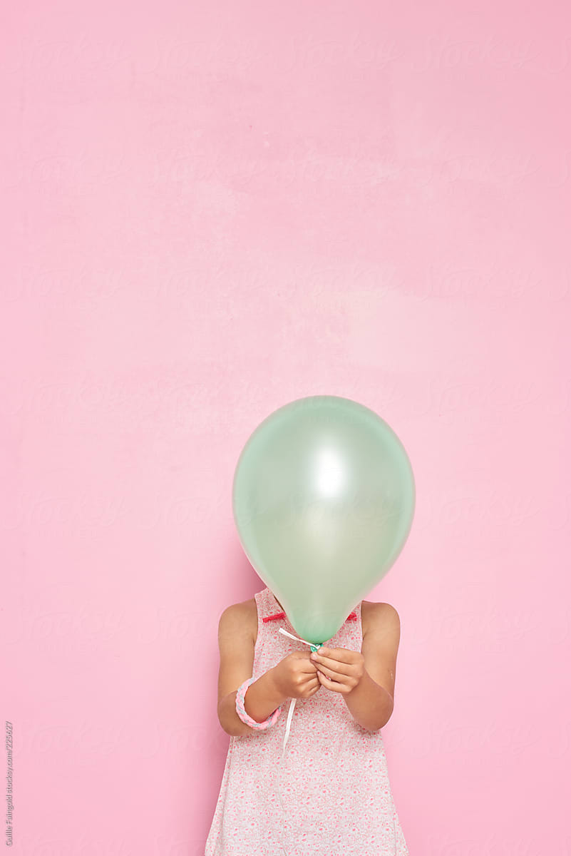 Unrecognizable girl with green balloon