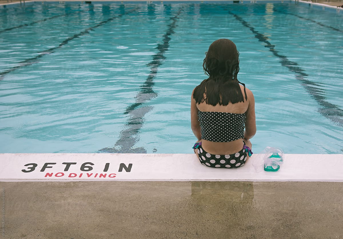 Girl Sitting at Edge of Pool on Rainy Day