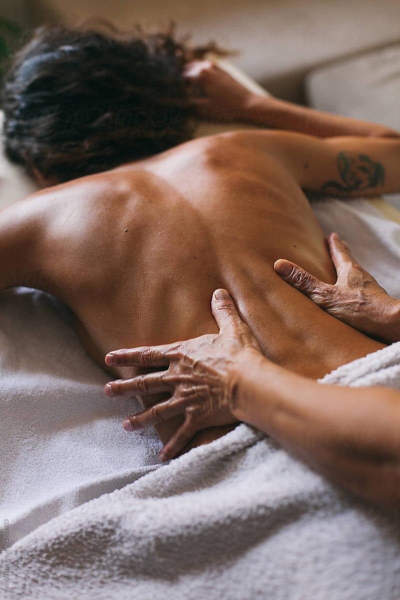 Masseur doing massage of female back indoor
