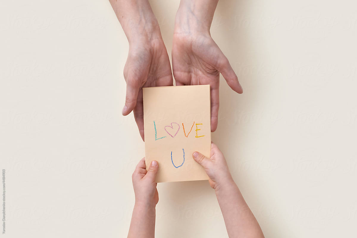 Kid giving greeting card with text Love U to mum