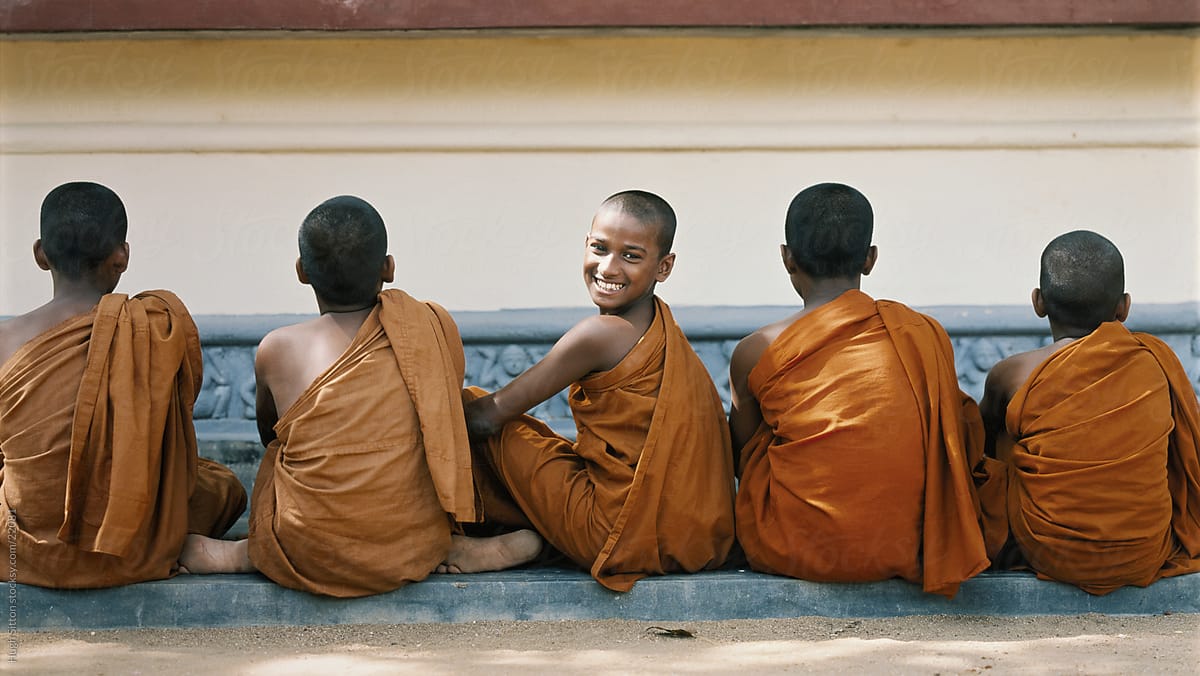 Young novice monks sitting outside monastery. Sri Lanka