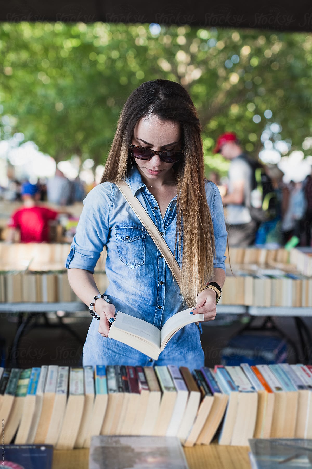 Young woman looking for a book in a market