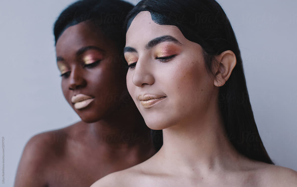 Beauty portrait of two girls with different color of skin and the same make up