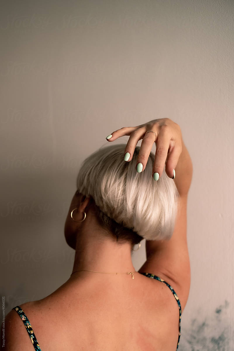 Anonymous woman with edgy hair style and colorful nails