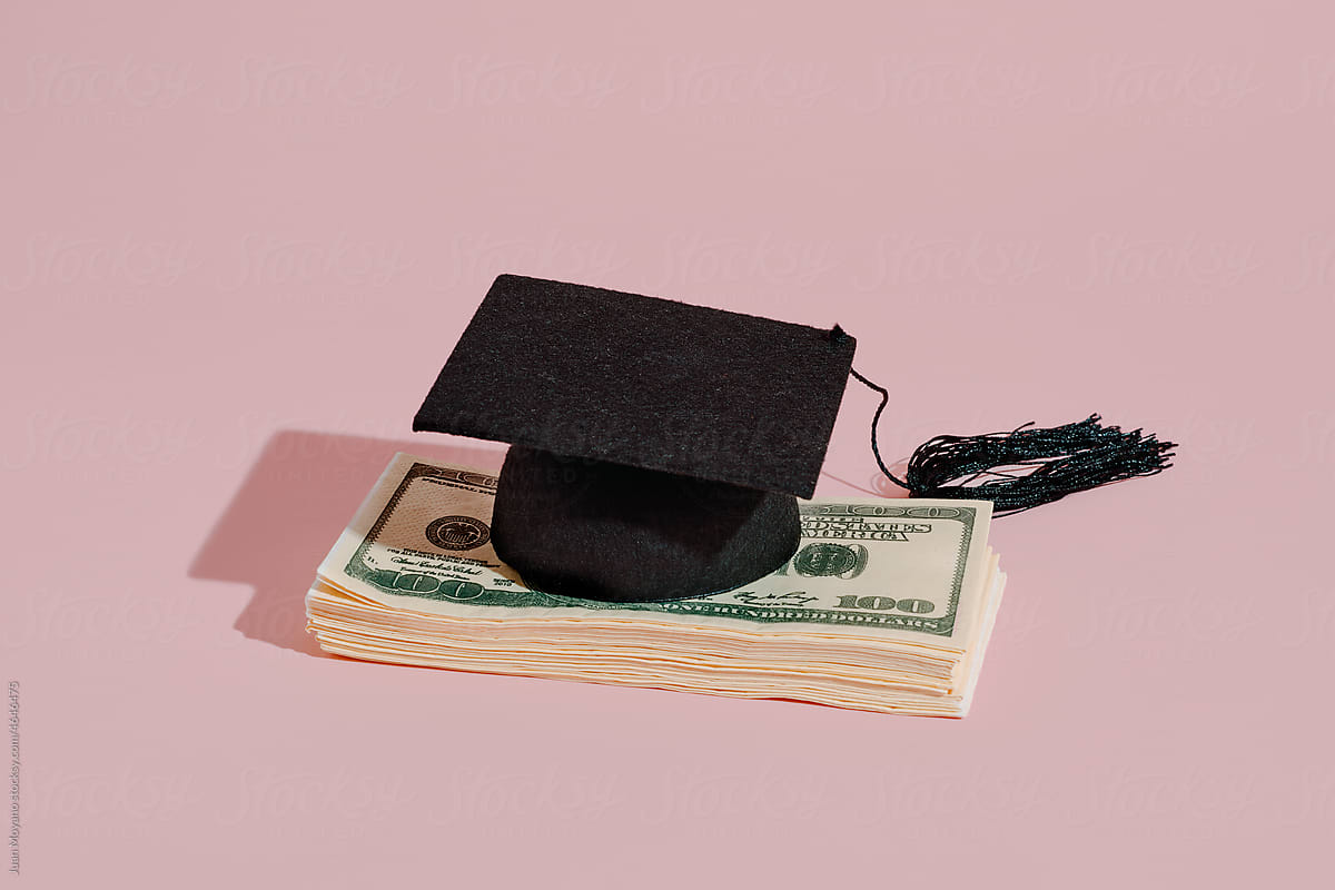 graduate cap on a pile of banknotes