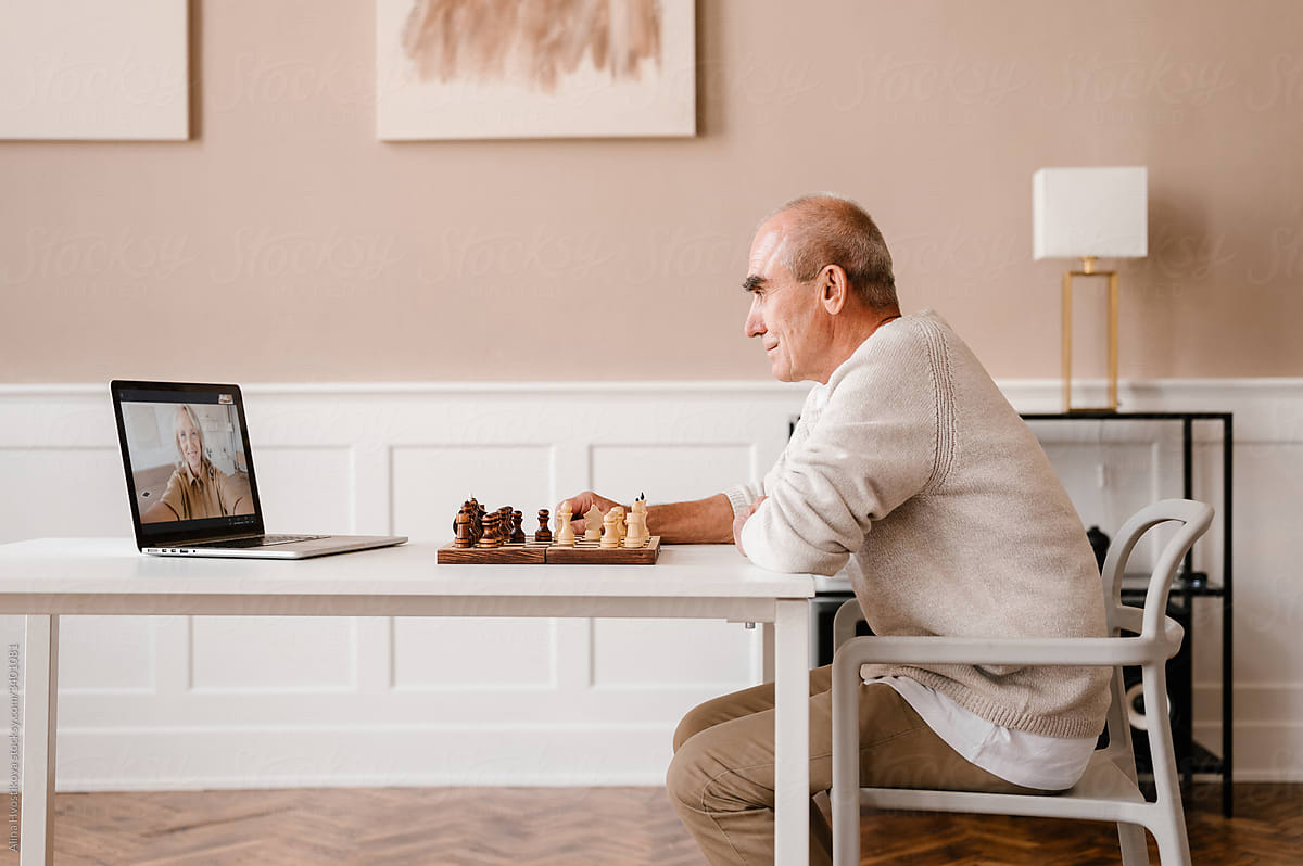 Senior man playing chess with online partner