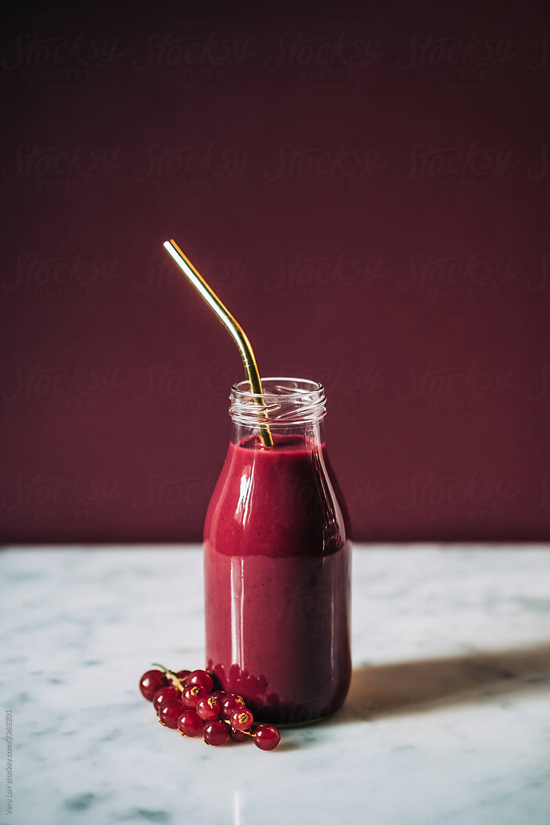 Pink smoothie, currants and metal straw