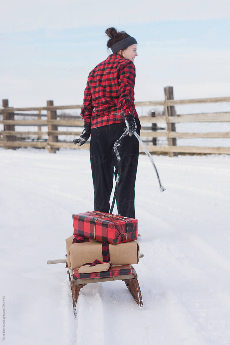 young woman pulling sled with gifts