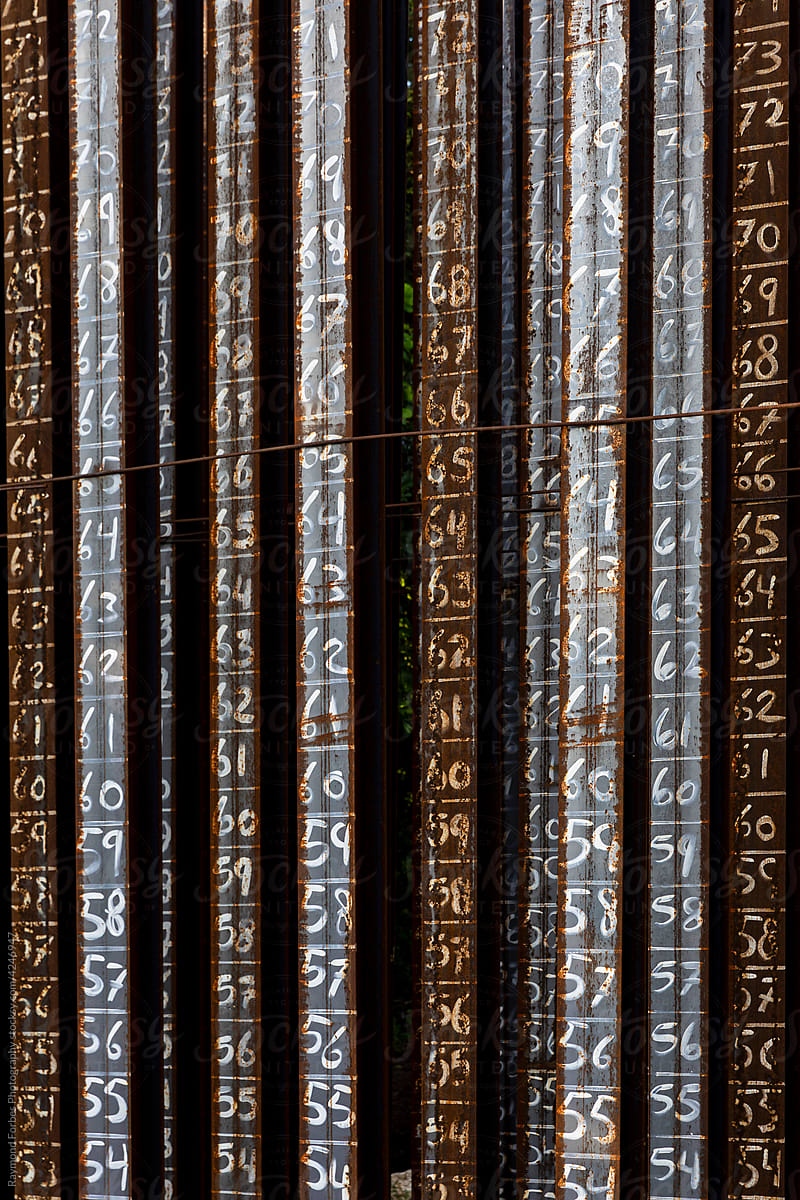 Vertical Steel pilings with numbers at bridge