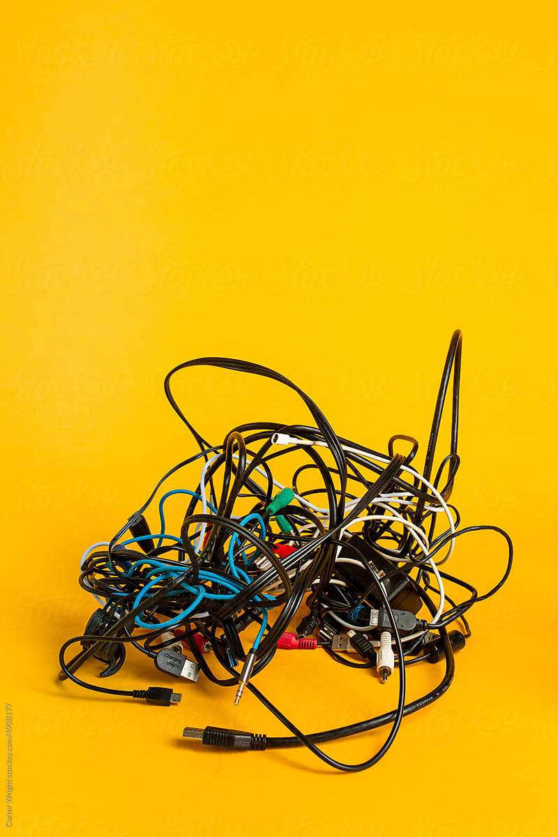 A messy bundle of tangled electronic cords and wires