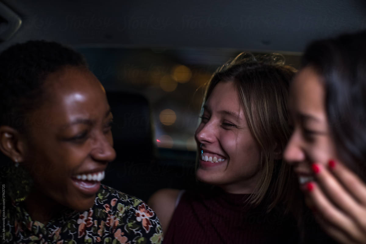 Friends Laughing Together In The Back Of A Taxi Del Colaborador De Stocksy Jovo Jovanovic