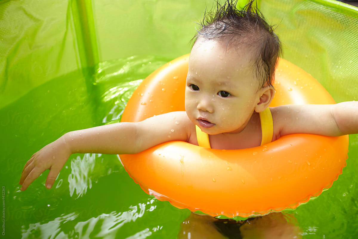 Asian kid playing in small swimming pool
