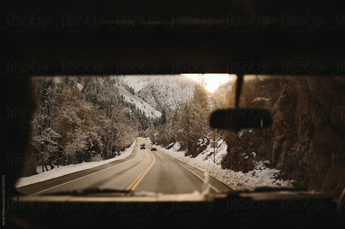 golden hour mountain view in winter through car windshield