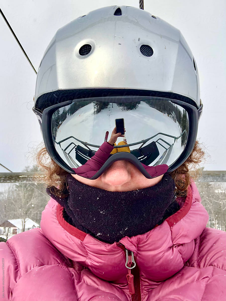 selfie of middle aged woman on chairlift, ski mountain.