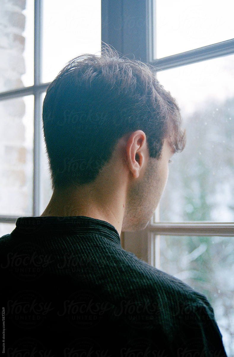 Analog portrait of a young man by the window