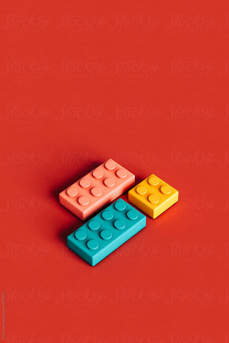 pink, blue and yellow building blocks on red background