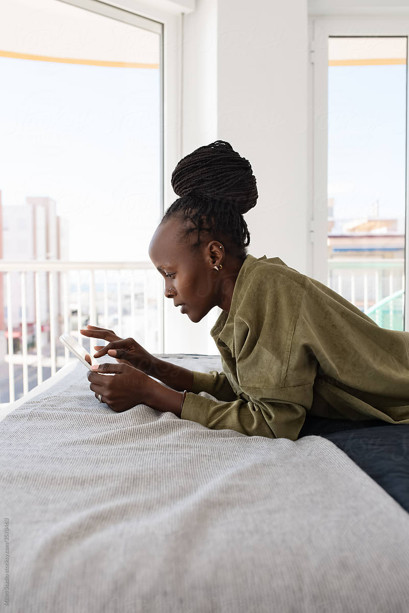 Focused African woman browsing tablet