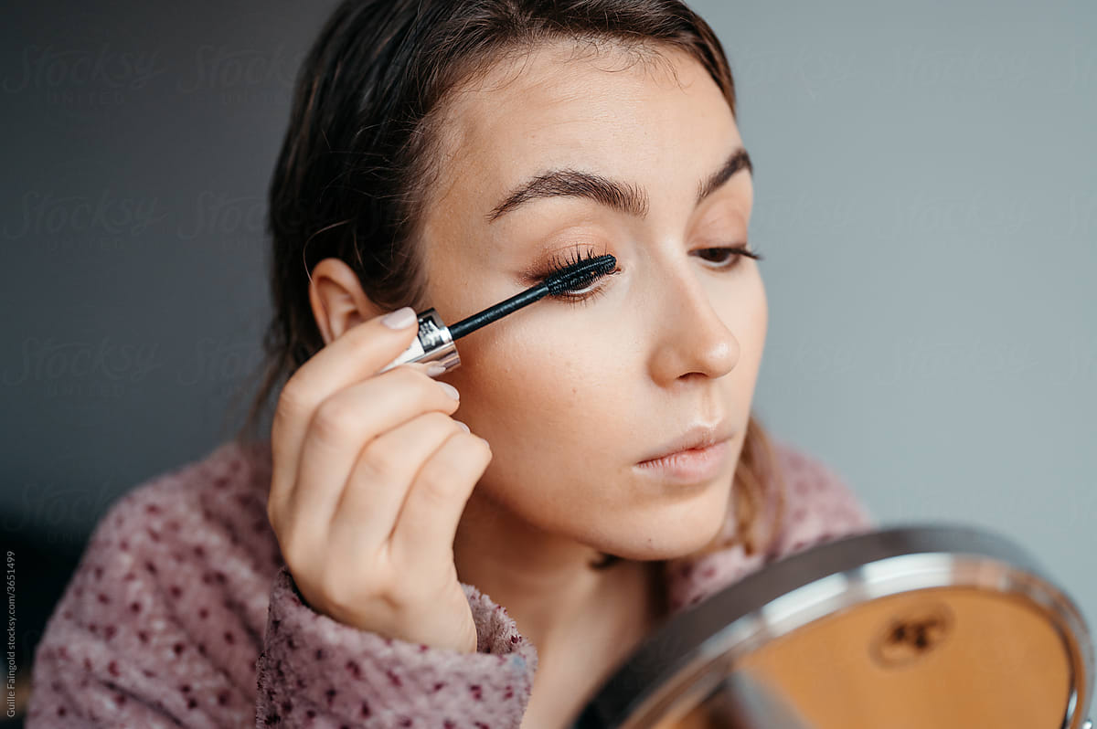 Woman applying makeup in morning