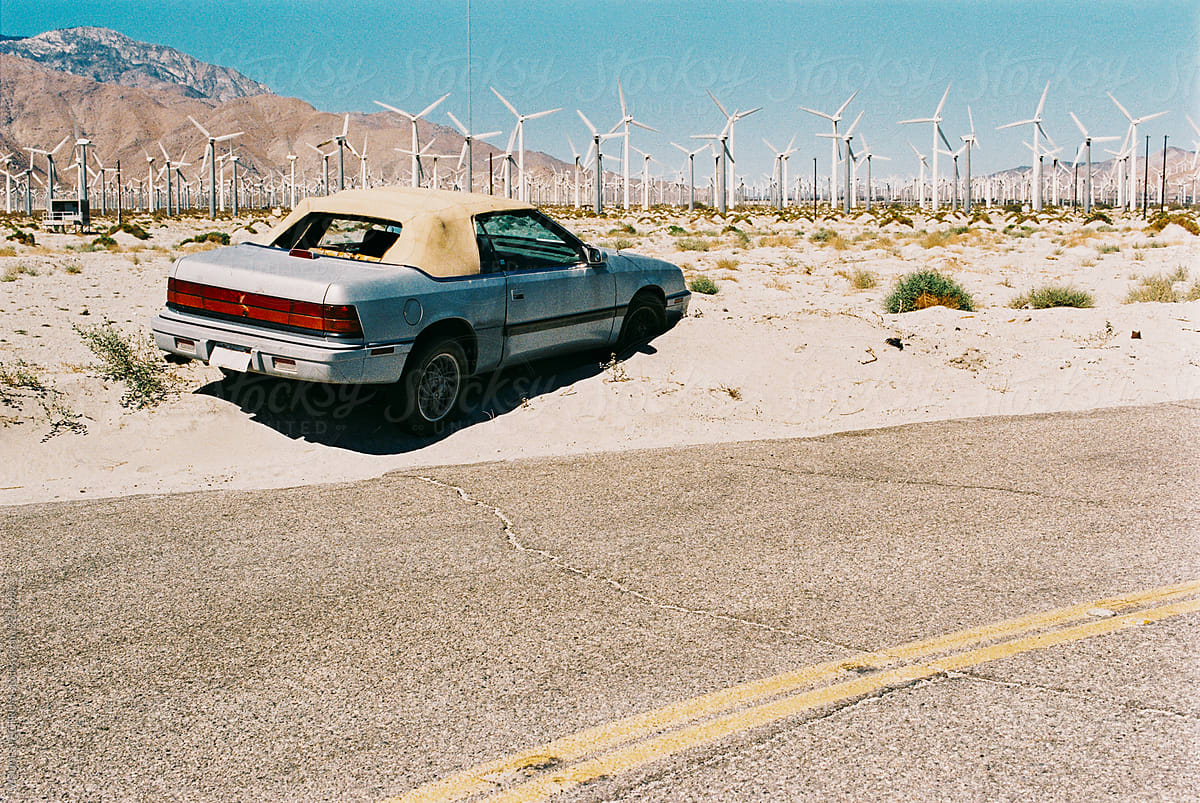Broken Car Next to Wind Turbine Farm in California Desert Shot on Film