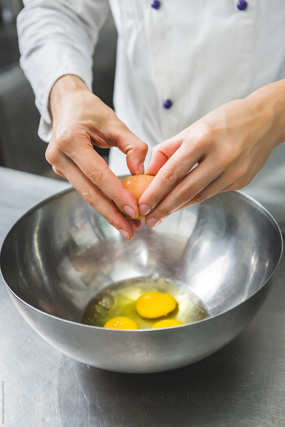 Pastry Chef Breaking some Eggs for a Cake