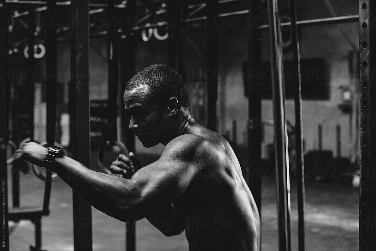 Young, fit black man training hard in fitness gym - boxing